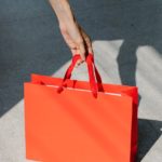 woman taking red gift bag from floor